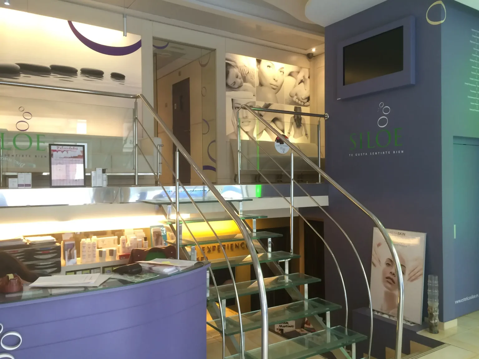 Recepción de Clínica SILOÉ en Valladolid, con el mostrador y la escalera de cristal